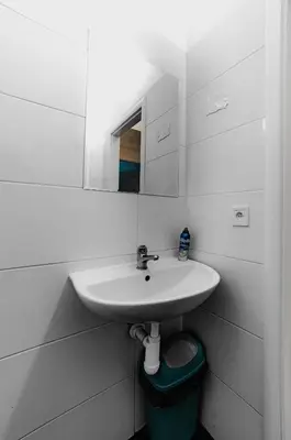 a white bathroom with a sink and a mirror at Hostel Karlin in Prague