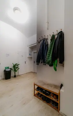 a room with a white wall with a bunch of jackets at Hostel Karlin in Prague