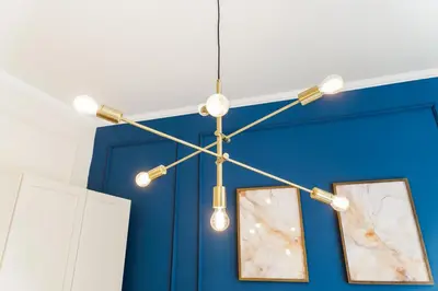 a chandelier with lights hanging from a blue wall at Rentero Wenceslas Square Apartments in Prague