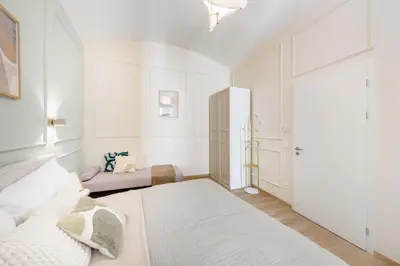 a white room with a bed and a couch at Rentero Wenceslas Square Apartments in Prague