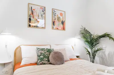 a bedroom with a bed with four pictures on the wall at Rentero Wenceslas Square Apartments in Prague