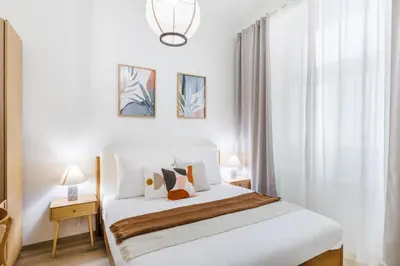 a bedroom with a bed with white sheets and pillows at Rentero Wenceslas Square Apartments in Prague