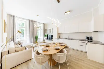 a kitchen and living room with a table and chairs at Rentero Wenceslas Square Apartments in Prague