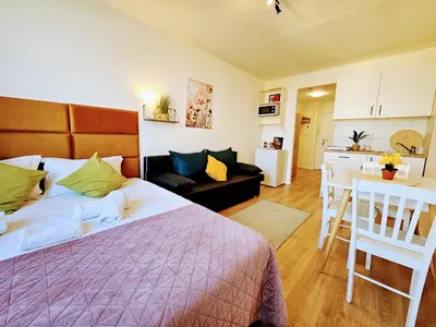 a bedroom with a bed and a living room at LIVE-INN PRAGUE DELUXE SUITE FOR 1-4 GUESTS, 20 Mins to center, Lift, Gym, Reception, Parking, Roof Terrace, Game & Party in Prague