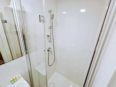 a shower with a glass door next to a toilet at LIVE-INN PRAGUE DELUXE SUITE FOR 1-4 GUESTS, 20 Mins to center, Lift, Gym, Reception, Parking, Roof Terrace, Game & Party in Prague