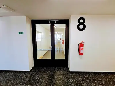 a room with a door with a fire extinguisher at LIVE-INN PRAGUE DELUXE SUITE FOR 1-4 GUESTS, 20 Mins to center, Lift, Gym, Reception, Parking, Roof Terrace, Game & Party in Prague