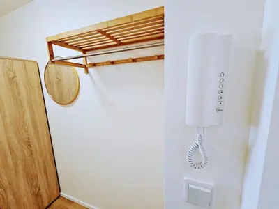 a white phone hanging on a wall next to a door at LIVE-INN PRAGUE DELUXE SUITE FOR 1-4 GUESTS, 20 Mins to center, Lift, Gym, Reception, Parking, Roof Terrace, Game & Party in Prague