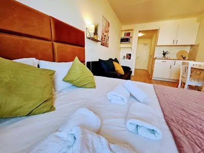 a large white bed with towels on top of it at LIVE-INN PRAGUE DELUXE SUITE FOR 1-4 GUESTS, 20 Mins to center, Lift, Gym, Reception, Parking, Roof Terrace, Game & Party in Prague