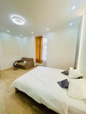 a bedroom with a large white bed and a couch at New Design apartment right next Wenceslas Square in Prague