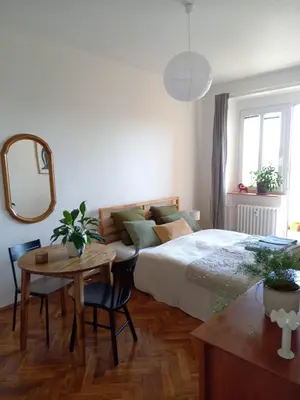 a bedroom with a bed and a table and a mirror at Hezký apartman s balkonem in Prague