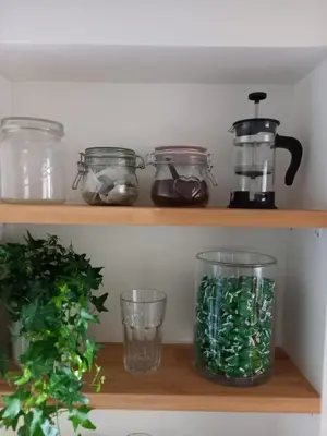 a shelf with glass jars and a blender at Hezký apartman s balkonem in Prague