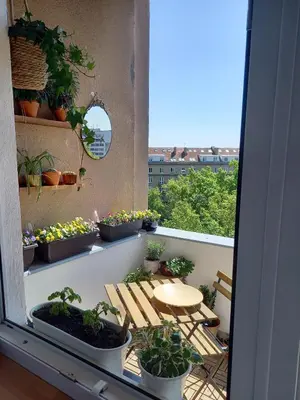 a balcony with potted plants and a table on it at Hezký apartman s balkonem in Prague