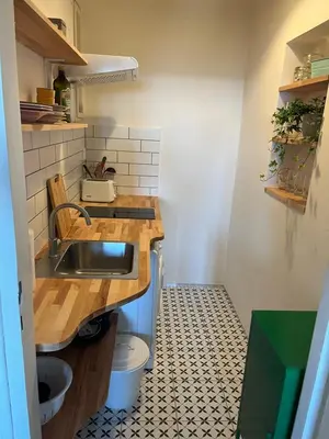 a small kitchen with a sink and a tiled floor at Hezký apartman s balkonem in Prague