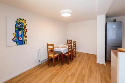 a dining room with a table and chairs and a refrigerator at Apartman u Rudolfa II in Brandýs nad Labem-Stará Boleslav