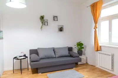 a living room with a couch and a window at Cozy Retreat by Wenceslas Square in Prague