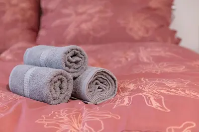 two rolled towels sitting on top of a bed at Cozy Retreat by Wenceslas Square in Prague