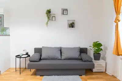 a living room with a gray couch and a table at Cozy Retreat by Wenceslas Square in Prague