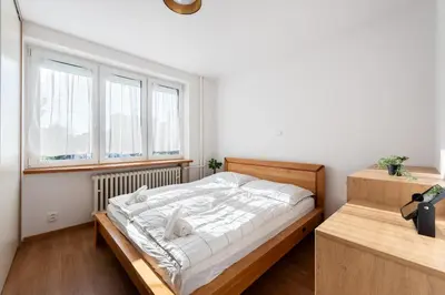 a bedroom with a bed and a large window at All-in 2 Bedroom Family Apartment in Prague