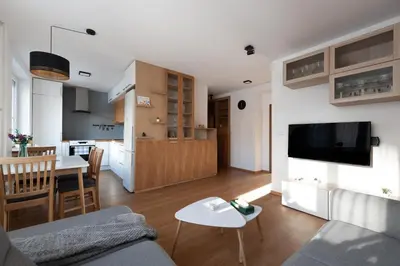 a living room and kitchen with a couch and a table at All-in 2 Bedroom Family Apartment in Prague