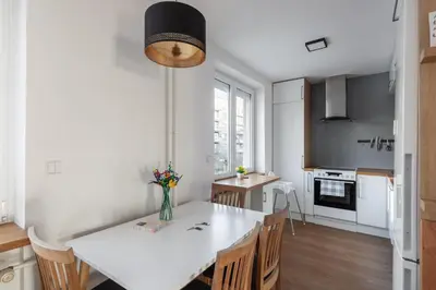 a kitchen and dining room with a white table and chairs at All-in 2 Bedroom Family Apartment in Prague