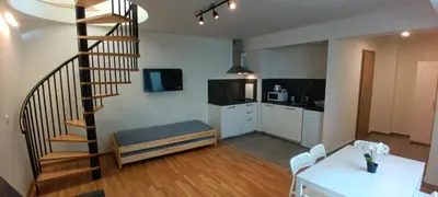 a living room with a spiral staircase and a kitchen at Brand new two room apartment #25 in Elite residence close to center in Prague