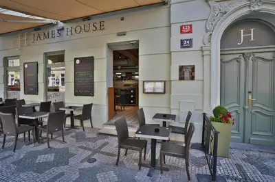 a restaurant with tables and chairs in front of a building at James Hotel & Apartments in Prague