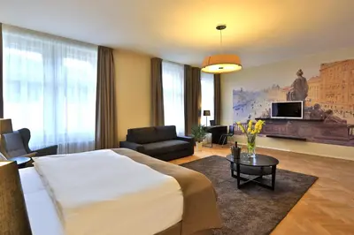 a bedroom with a large bed and a living room at James Hotel & Apartments in Prague