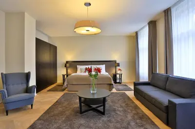 a bedroom with a bed and a couch and a table at James Hotel & Apartments in Prague