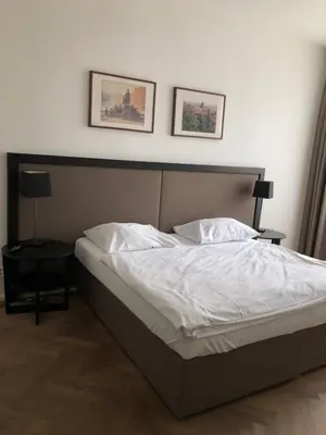 a bed in a bedroom with two pictures on the wall at James Hotel & Apartments in Prague