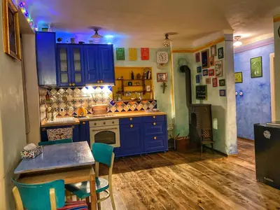 a kitchen with blue cabinets and a table with chairs at Casa Mexico in Roztoky