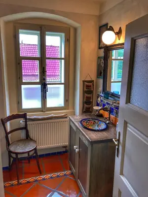 a kitchen with a counter and a chair and windows at Casa Mexico in Roztoky
