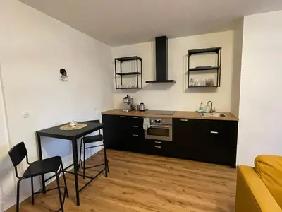 a kitchen with black cabinets and a table and chairs at New Apartment near to Elbe bicycle path in Roudnice nad Labem
