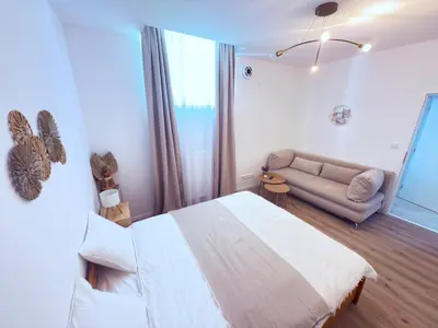 a bedroom with a large bed and a couch at Cosy Cave Station in Prague 5 in Prague