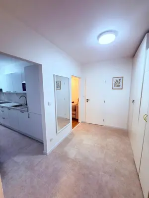 an empty living room with white walls and a large mirror at Cosy Cave Station in Prague 5 in Prague