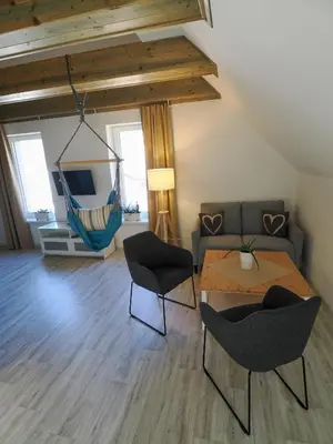 a living room with a couch and a table and chairs at Apartmány Křivoklát in Křivoklát