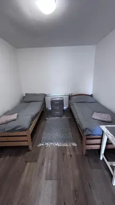 two twin beds in a room with wooden floors at Sleep & Go Czech Republic - Praha - západ in Jeneček