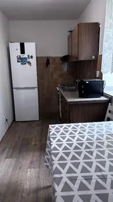 a kitchen with a white refrigerator and a wooden floor at Sleep & Go Czech Republic - Praha - západ in Jeneček