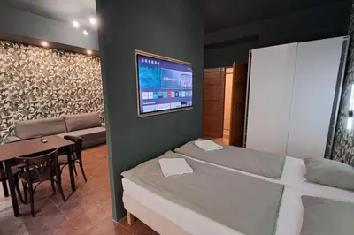 a room with two beds and a table and a tv at Contemporary Zizkov Studio -001- in Prague
