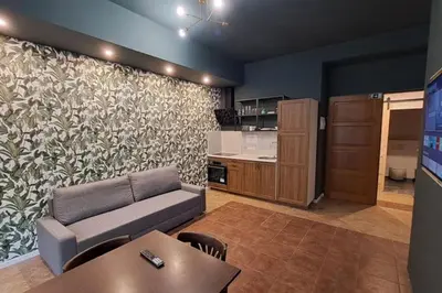 a living room with a couch and a kitchen at Contemporary Zizkov Studio -001- in Prague