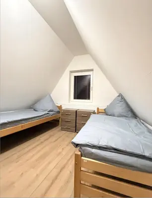 a room with two beds and a tv in a attic at Sleep & Go Czech Republic - Kralupy nad Vltavou in Mikovice