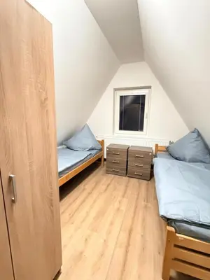 a attic bedroom with two beds and a window at Sleep & Go Czech Republic - Kralupy nad Vltavou in Mikovice