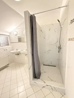 a white bathroom with a shower and a sink at Sleep & Go Czech Republic - Kralupy nad Vltavou in Mikovice