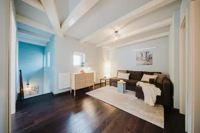 a living room with a couch and a table at Prague Days - Attic Maisonette with Netflix and Workspace in New Town in Prague