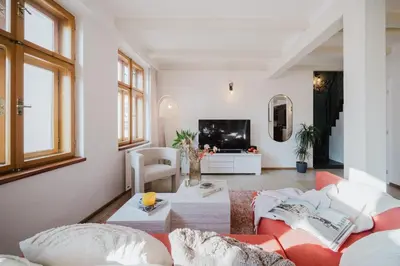 a living room with a couch and a tv at Prague Days - Attic Maisonette with Netflix and Workspace in New Town in Prague