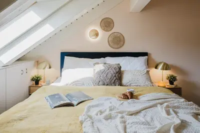 a bedroom with a bed with two books on it at Prague Days - Attic Maisonette with Netflix and Workspace in New Town in Prague