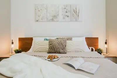a bed with a book and a plate of food on it at Prague Days - Two-bedroom Apartment with Parking Space and 2 bathrooms in Vinohrady in Prague