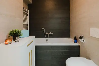 a bathroom with a bath tub and a toilet at Prague Days - Two-bedroom Apartment with Parking Space and 2 bathrooms in Vinohrady in Prague