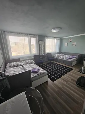 a room with two beds and chairs in it at Westfield apartment in Prague