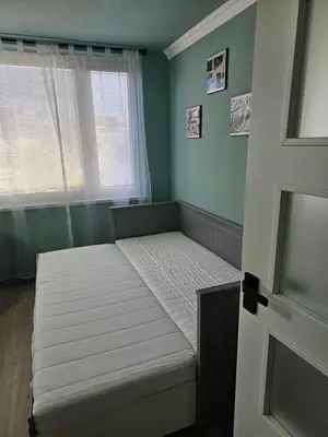a small bedroom with a bed with a window at Westfield apartment in Prague