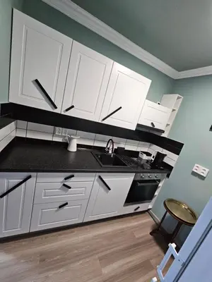 a kitchen with white cabinets and a sink at Westfield apartment in Prague